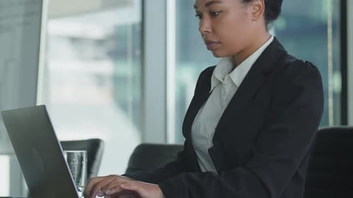 Business Woman in Black Suit Type on Keyboard of Laptop Afro American Woman Work in Office Make