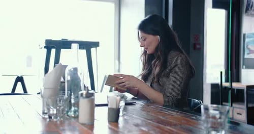 Cinematic Shot of Young Caucasian Brunette Female IT Freelancer Using Laptop to Work Online at Light
