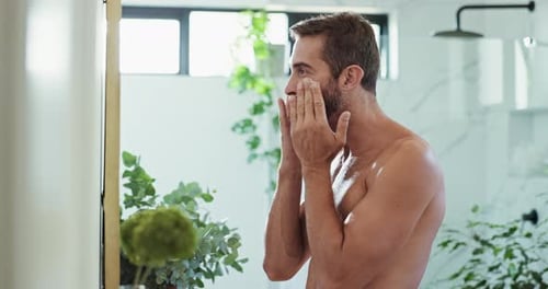 Man Applies Facial Cream in Modern Bathroom
