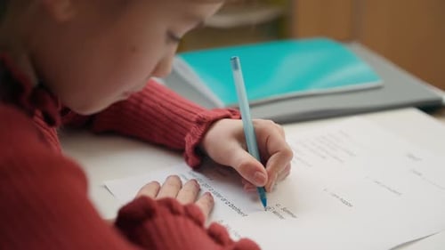 Kaukasisches, kluges, kluges kleines Mädchen, das einen Sprachtest macht, die richtige Antwort, die richtige Antwort, Lernaufgabe, Prüfungsarbeit, Schreiben