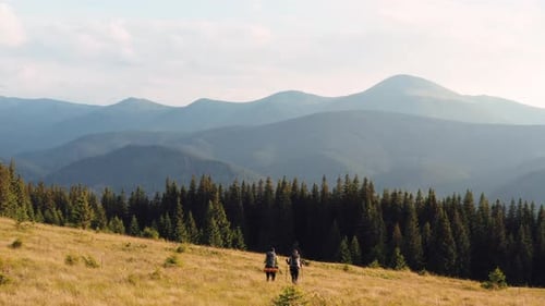 Couple of tourists walks up on hill. Majestic Carpathian Mountains. Beautiful landscape of untouched