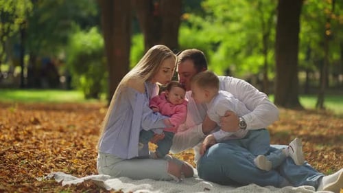 Family Relaxing Together in the Beautiful Autumn Park