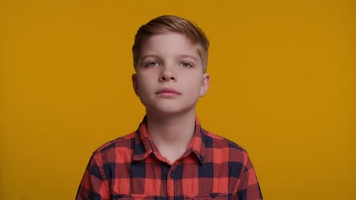 Boy Smiling at Camera on Yellow Background