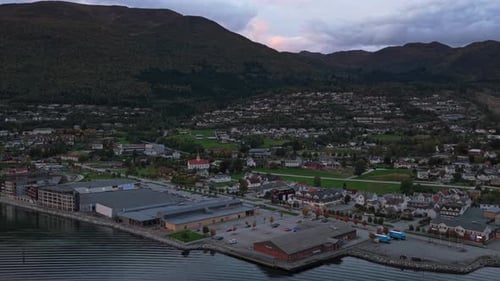 Drone shot of Nordfjordeid glowing at dusk in stunning fjord setting