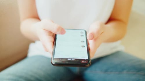 Person Using Smartphone Scrolling Through Social Media