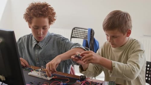 Two Clever Classmates Connecting Wires to Components during School Project
