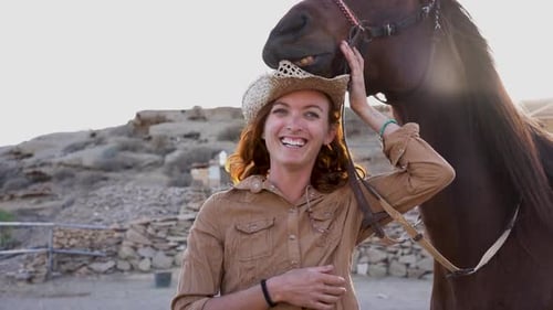 Happy Woman Petting Horse in Rural Setting