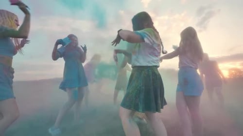 School Friends Sprinkled with Colorful Powders at Sunset
