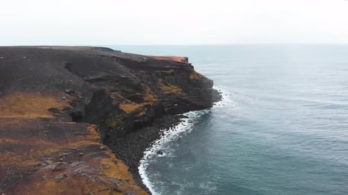 Volcanic Krísuvíkurberg cliffs above atlantic ocean waves, Iceland.