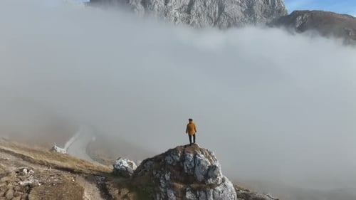 Aerial video of a tourist standing in front of a mountain peak in Slovenia