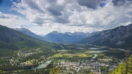 Timelapse of Clouds and Shadows Flying Over Untouched Wilderness Valley and Mountain Town. Shot in B
