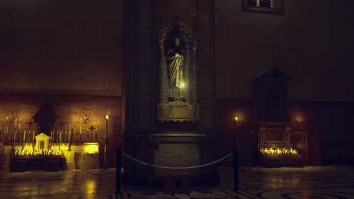 Canto silencioso do relicário banhado por luzes cintilantes de velas e sombras