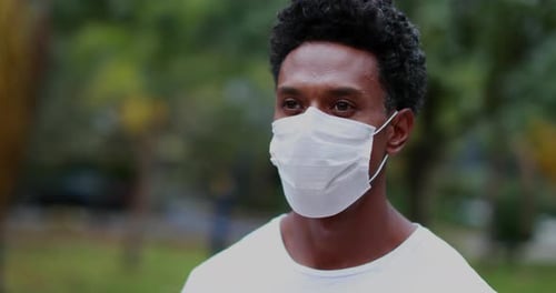 Man Walking Outdoors Wearing Protective Face Mask
