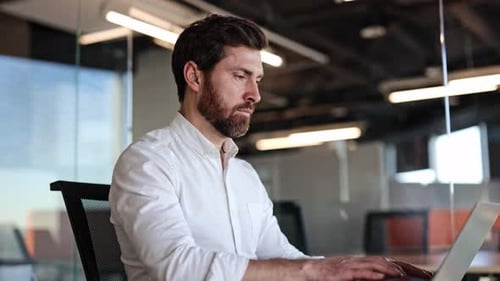 Businessman Working on Laptop in Modern Office