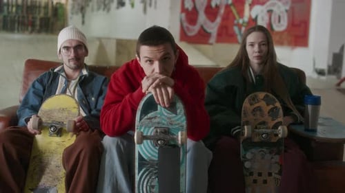 Three Friends with Skateboards Hanging Out Indoors