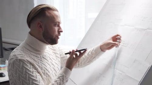 Concentrated Architect Works in Loft Using Drawing Board Workplace of Young Engineer in Modern