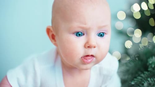 Baby with Blue Eyes Sticking Tongue Out At Camera