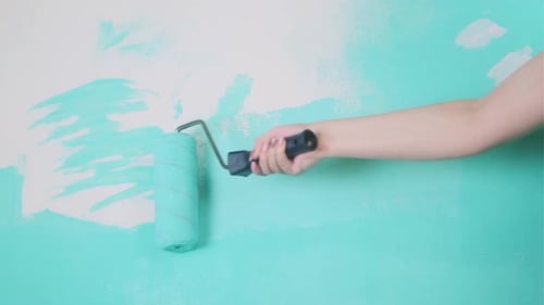 Applying Turquoise Paint to Wall with Roller