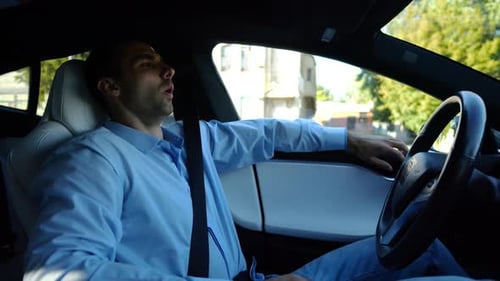 Male Businessperson Experience to Ride an Autonomous Self Driving Electric Car at Urban Road