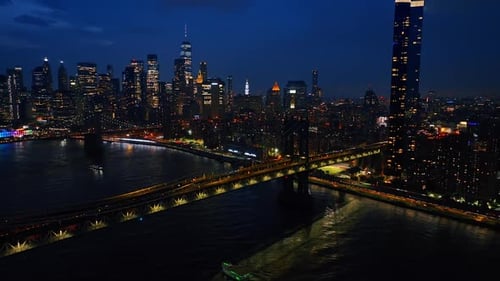 Sparkling skyline of New York at night. Drone footage of the urban scenery from above the river.