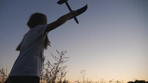 Child with Toy Airplane at Sunset