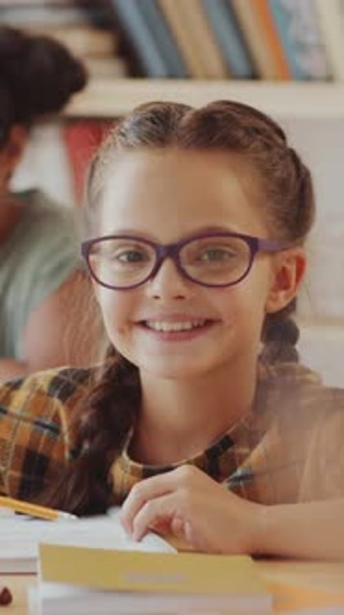 Smiling Girl with Braids Studies in Classroom