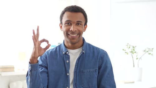 Young Man Gives OK Hand Gesture, Smiles