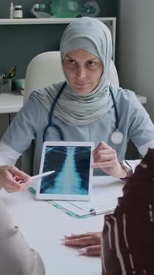 Medical Professional Explains X-Ray on Tablet to Patient