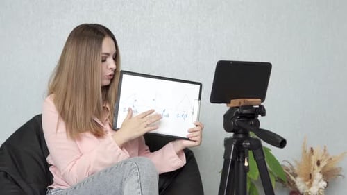 A geometry teacher conducts an online lesson with high school students via a tablet.