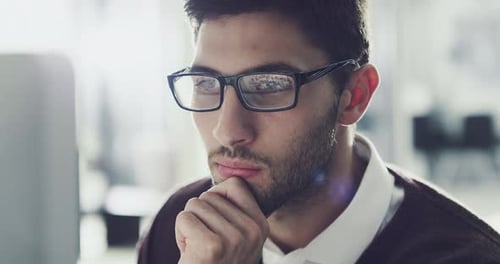 4k footage of a focussed young businessman working behind his computer screen in the office