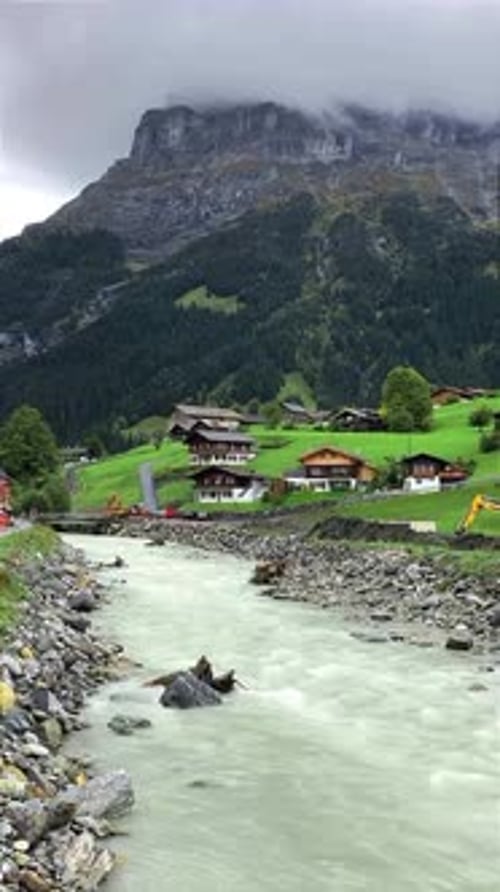 Beautiful Alpine Landscape with Wooden Houses and Flowing River