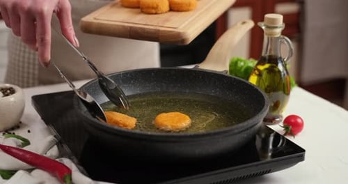Woman Puts Cheese Balls Into Frying Pan with Hot Cooking Oil