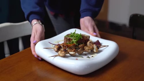 Plated Steak and Mushrooms Served at Restaurant Table
