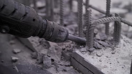 Construction Worker Crumbles Concrete with a Jackhammer