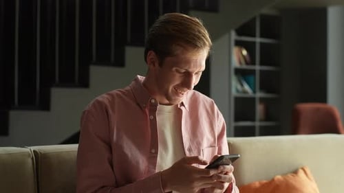 Young Man Relaxing at Home Using Phone