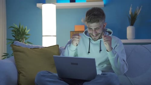 Man Using Laptop on Couch at Home