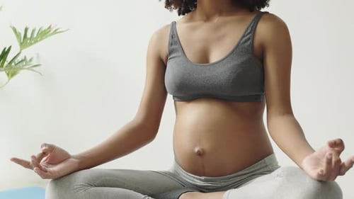 Pregnant Woman Meditating Indoors on Yoga Mat