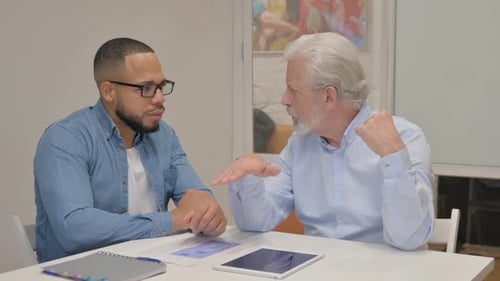 Senior Businessman Talking with Young Man in Office