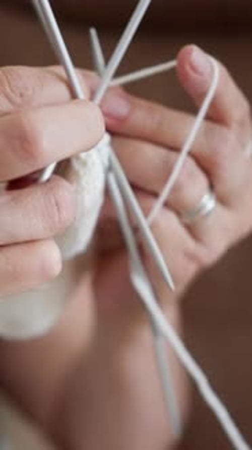 Woman Knits a Light Garment with Needles