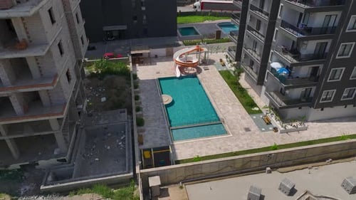 Aerial View Pool With a Water Slide Families Enjoying Summer Fun in the Sun