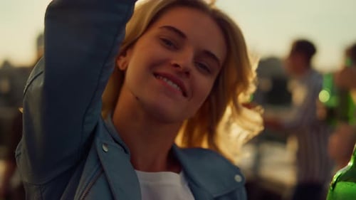 Woman Dancing with Friends on a Rooftop at Sunset