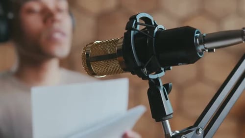 Man Recording Audio with Microphone in Home Studio