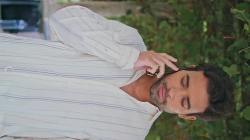 Handsome Man Talking on Phone Outdoors in Daylight