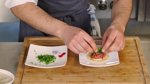 Chef Prepares Gourmet Dish on Wooden Cutting Board