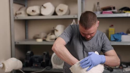 Gloved Adult Works on White Object in Workshop