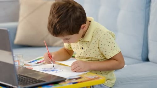 Boy Drawing Art With Paint Brush at Home