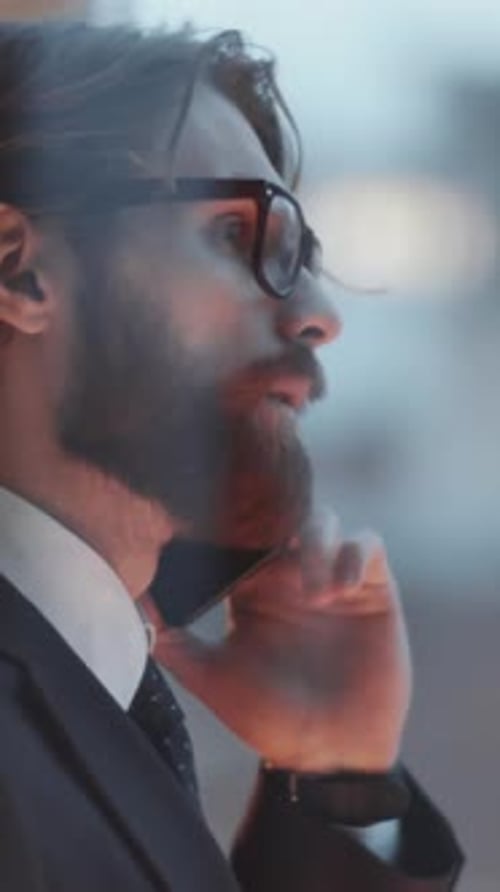 Businessman Having Conversation on Cell Phone in Office