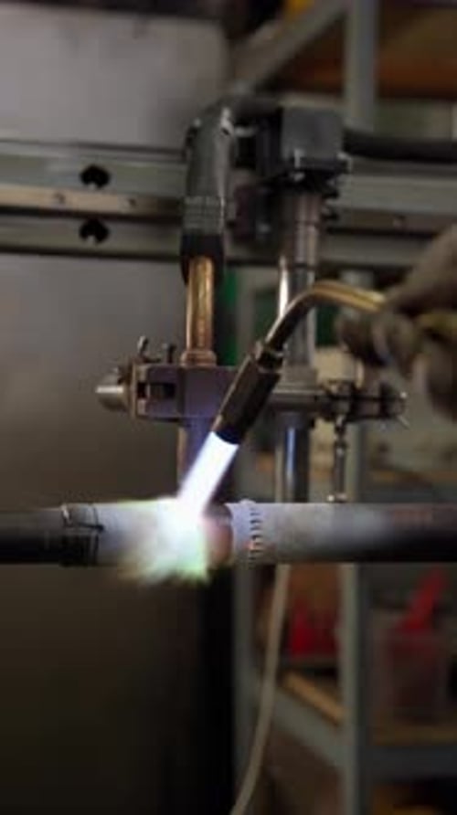Schweißbrenner verbindet Metallrohre in der Werkswerkstatt Konzept zum Schweißen von Rohren