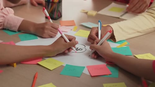 Brainstorming Meeting Around Table with Sticky Notes and Pens