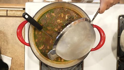 Adding Wild Rice to Soup Preparation on Stove